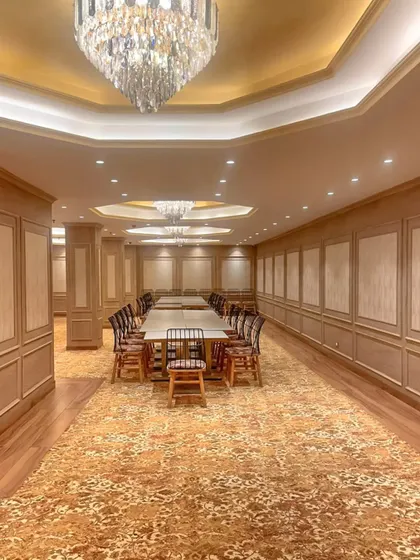 A long view of the Bhopal banquet hall, showcasing the series of chandeliers and the classic wall treatments that give the large room a sense of rhythm and grandeur.