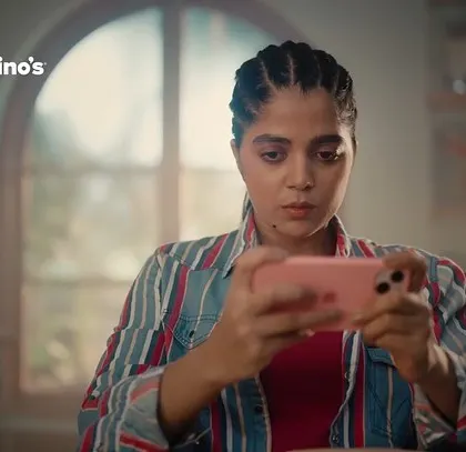 A close-up of one of the actors from the Domino's commercial. Her trendy and relaxed look, complete with braided hair, was designed to resonate with a young, modern audience.