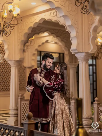 A playful and romantic moment captured under the elegant arches of a palace-style studio set. The rich velvet outfits and the grand architecture combine to create a feeling of modern royalty.