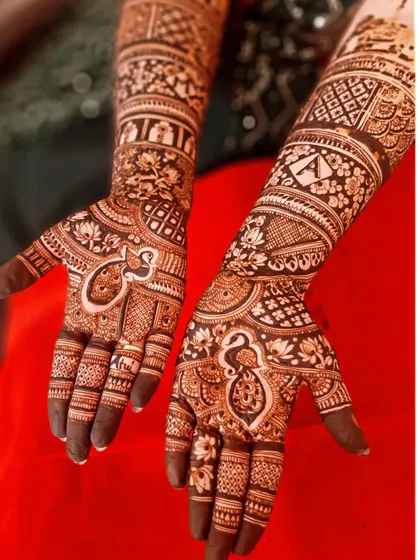 A beautiful bridal design featuring the sacred 'Om' symbol and a peacock on the palms, surrounded by intricate floral and geometric patterns.