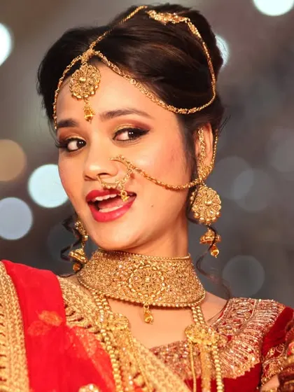A fun and expressive portrait of a bride in her red and gold wedding attire.