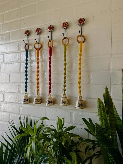 Our miniature macrame set of bells is now available in two variants. This image shows a set of five, with intricately knotted colorful cords and hand-painted ceramic bells, complete with matching ceramic hooks.