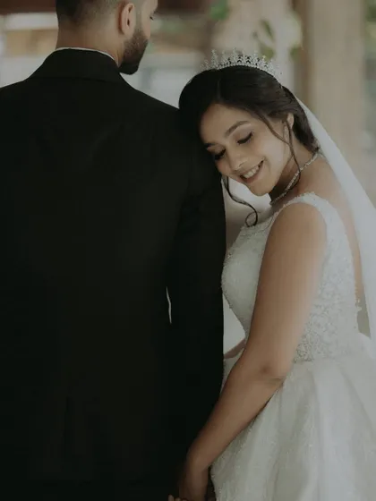 A quiet, loving moment with the bride resting her head on the groom's shoulder.