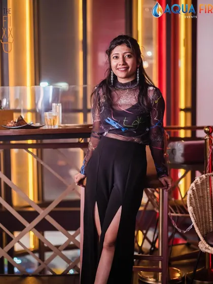 A guest looking chic and enjoying the ambiance by the well-lit bar.