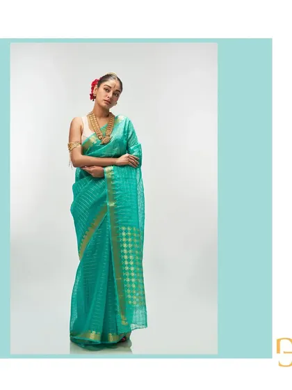 This light sea green silk organza saree features delicate gold zari checks, creating a refreshing and elegant look.