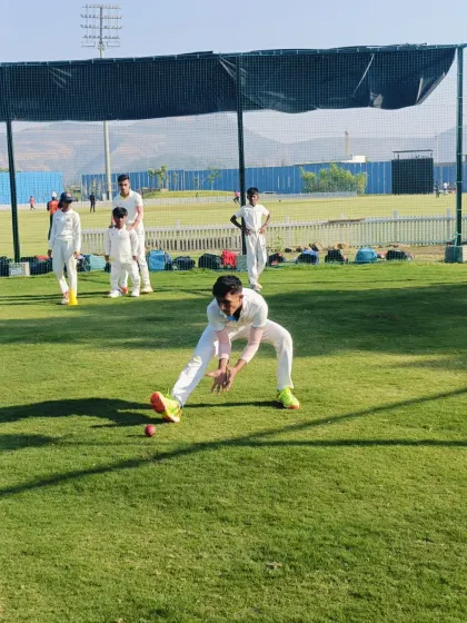 Getting low and staying agile. This action shot shows a player practicing a low catch, a fundamental skill for saving crucial runs in the infield.
