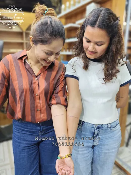 Another pair of friends showing off their matching script tattoos. A shared quote or phrase is a wonderful way to solidify a bond.