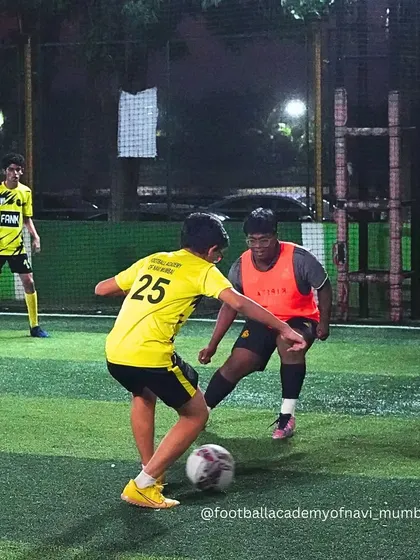 A player in a bib defends against an attacker. These match scenarios are crucial for teaching defensive positioning and tackling.