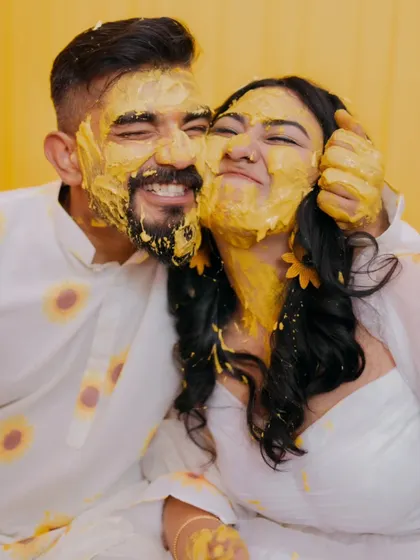 The Haldi ceremony is pure, unscripted fun. I focus on capturing the genuine laughter and playful energy, like this moment where the couple is covered in turmeric paste, completely lost in their joy.