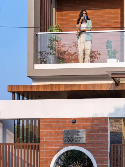 A detailed crop of the Sarjapur facade, showing the texture of the brickwork and the clean finish of the balcony.