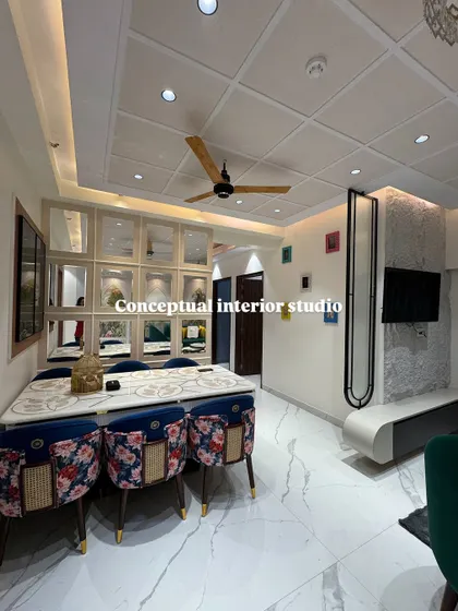 A look at a 4BHK dining space in Noida Extension. The floral print chairs add a pop of color and personality, complemented by the mirrored crockery unit in the background.