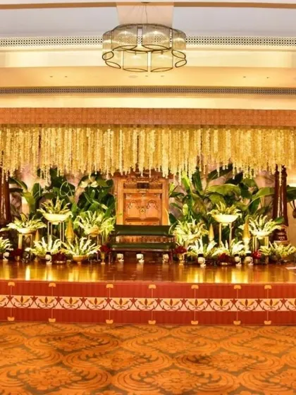 A regal and traditional engagement stage setup. We used a canopy of cascading jasmine, brass urlis with floating flowers, and large banana plants to create a truly royal ambiance.