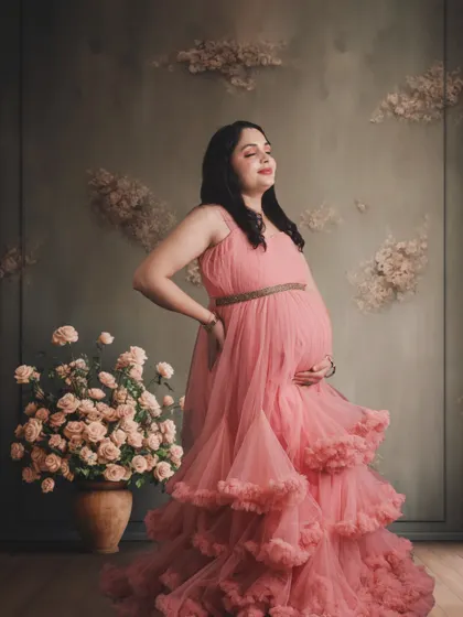 A serene portrait in a pink ruffled gown, set against a textured, artistic backdrop for a timeless, classic feel.