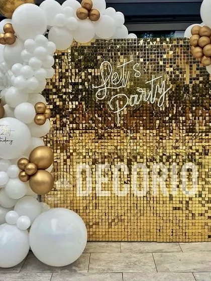 A gold shimmer wall is a versatile and high-impact backdrop for any celebration. Here, I've paired it with a classic white and gold balloon garland and a 'Let's Party' neon sign, creating a stylish photo booth area for a birthday, anniversary, or corporate event.
