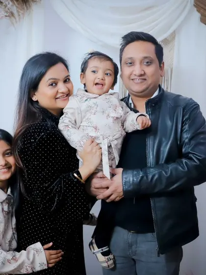 A lovely family of four posing in front of our pink and white floral studio backdrop.