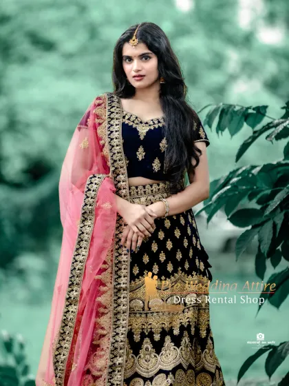 A portrait shot highlighting the contrast between the dark blue velvet and the bright pink dupatta.