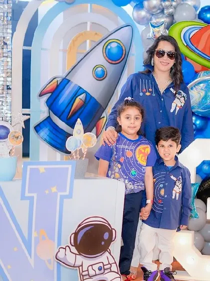 An out-of-this-world space-themed birthday party. The decor features rocket ships, planets, and a light-up number 3, perfect for a little astronaut's celebration.