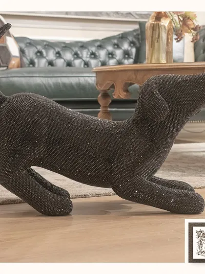 This charming black dog sculpture, covered in glittering crystals, is a playful and glamorous addition to your home. It's a fun piece that catches the light and draws the eye.