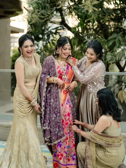 A candid moment with the bride and her bridesmaids. Her soft, authentic makeup look shines through, blending perfectly with the vibrant colors of her traditional Paithani saree for her engagement ceremony.