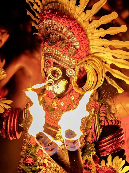 A series showing the Karim Gullikan Theyyam performance, surrounded by devotees and fire. These images document the energy of the crowd and the deity's commanding presence during the ritual.