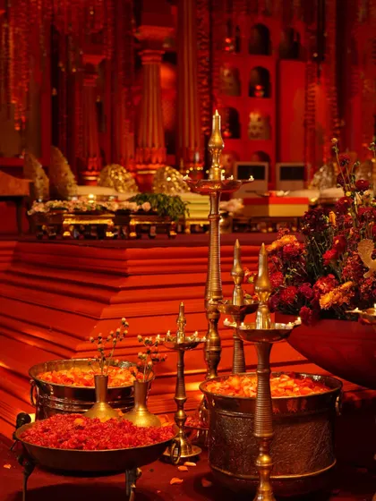 A close-up of the traditional brass lamps and bowls of flowers that adorned the 'Lal Bagh' mandap.