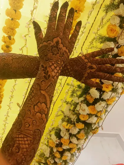 Bridal mehndi for Misba, set against a beautiful floral backdrop. The full arm design is intricate and perfect for her wedding celebrations.