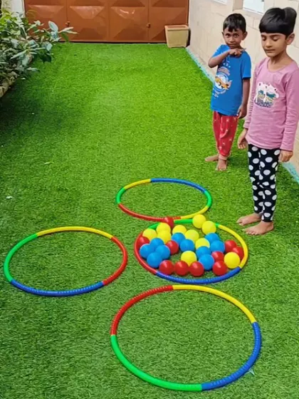 Children learn to sort colorful balls into matching hoops. This game combines physical activity with cognitive learning.