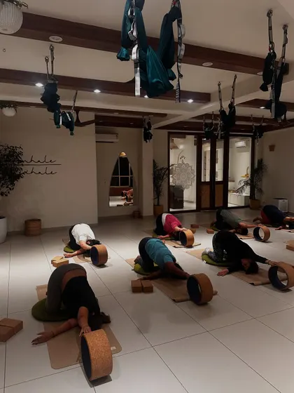 Students relax in a child's pose with the support of yoga wheels, a gentle way to end a challenging practice.