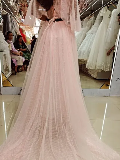 The back view of this custom pink gown shows off its beautiful long train, made from soft, dotted tulle for a touch of whimsical elegance.