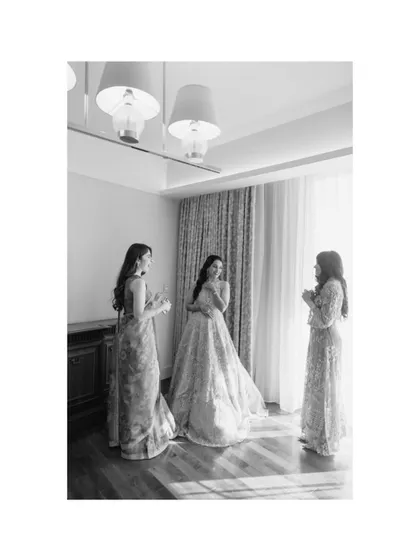 A black and white shot of Roha and her bridesmaids, sharing a moment by the window. The natural light and candid interaction make this a beautiful memory.
