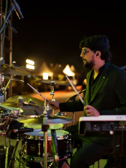 Our founding drummer plays under the stage lights, in the birthday portrait celebrating his place in the band.