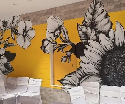 A full view of the sunflower mural, which serves as a vibrant backdrop for events and gatherings in the cafeteria space.
