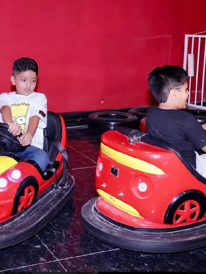 Kids having a great time driving the bumper cars around the dedicated track.