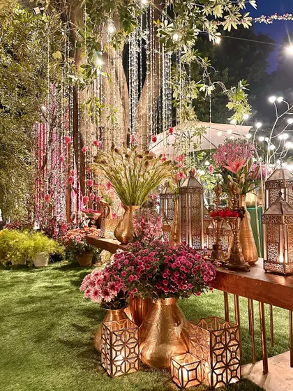 A lush arrangement of pink flowers and brass decor, creating a rich and opulent feel.