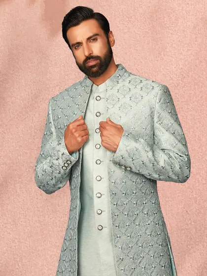 This powder blue layered sherwani has a subtle, regal feel. The intricate self-pattern on the jacket adds a layer of sophistication.