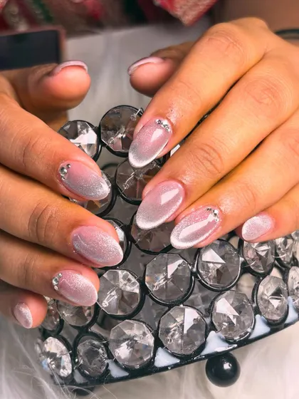 An ethereal and shimmery cat-eye effect on a sheer base, accented with tiny rhinestones at the cuticle for a touch of elegance.