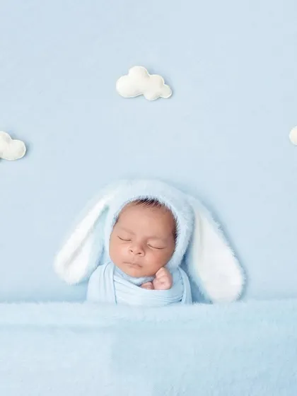 Dreaming in a blue sky. This setup with a bunny hat and fluffy white clouds creates a whimsical and serene atmosphere.