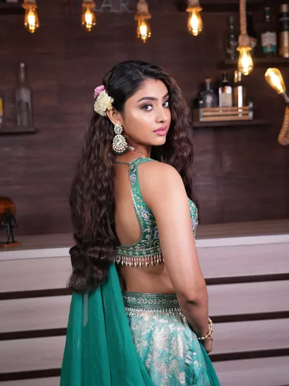 A back view of the deep wave hairstyle, showing how the floral accessory adds a touch of softness to the otherwise bold and textured look.
