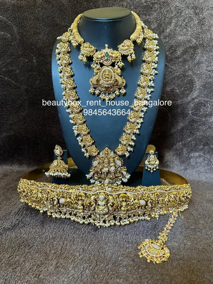 A complete and intricate temple jewellery set with pearl detailing. This rental includes a choker, multi-layered haaram, and a grand vaddanam.