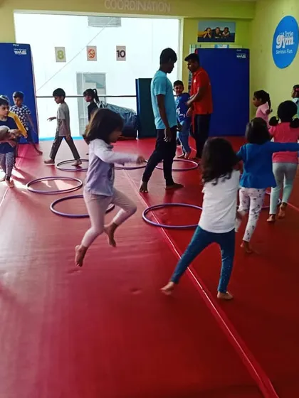 Our "Giggle Worms" enjoying a warm-up activity with hula hoops, learning about numbers and counting while they move.