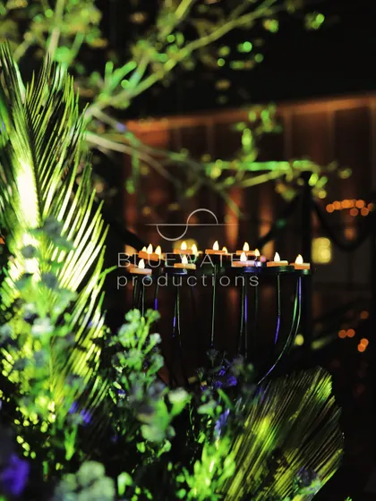 A candlelit detail, with tea lights glowing amidst fresh greenery.