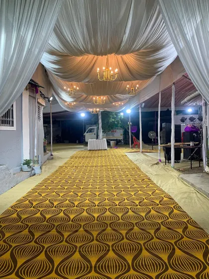 A view of the long walkway we prepared for an event. The space is transformed with a patterned carpet and a fully draped ceiling with beautiful chandeliers, ready for the guests to arrive.