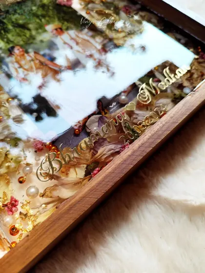 A close-up of the gold names and date, showing the glossy reflection on this custom wooden wedding frame.