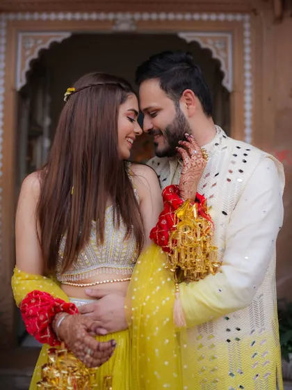 An intimate and romantic close-up from a Haldi ceremony, the couple's faces close together, their smiles full of love.