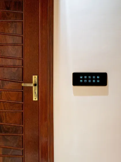 A clean and simple installation of a smart panel on a white wall next to a wooden door, embodying minimalist design.