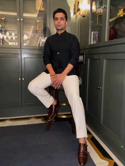 A full-length portrait, seated and composed. This shot captures the calm before the storm of a high-energy performance.