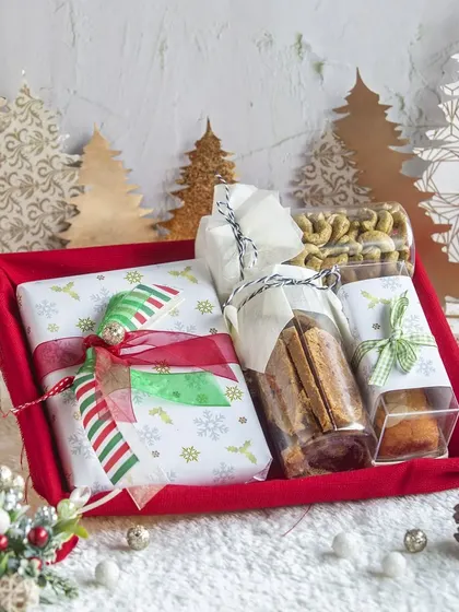 This Christmas hamper is beautifully wrapped in festive paper and filled with a variety of our holiday treats, including bar cakes and savory snacks.