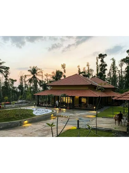 The modernized estate bungalow in Sakleshpur at sunset. We retained the traditional sloping roof and veranda while updating the structure and landscape to create a contemporary home rooted in vernacular style.