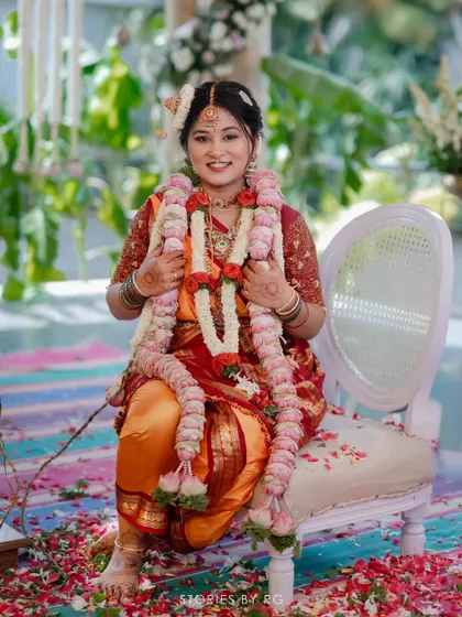 A joyful bride during her ceremony, adorned with flower garlands. Her makeup is fresh and radiant, capturing her happy spirit.