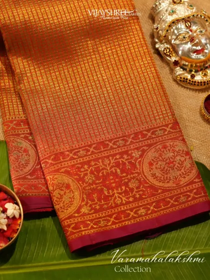 A classic festive Kanjivaram in shades of orange and red, featuring a checked body and a border with circular motifs.